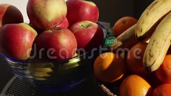 阳台桌上的橘子香蕉和苹果细节柳条和玻璃碗视频的预览图