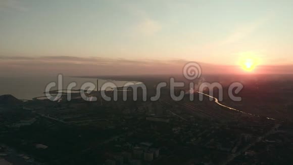 工业城市的日落在地平线上一个靠近大海的冶金工厂视频的预览图