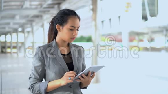 年轻工作妇女站在室外使用平板电脑视频的预览图