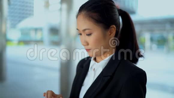 年轻的商务女性在户外与智能手机交谈视频的预览图