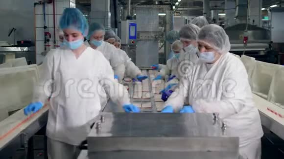 女技术员正在重新安置蟹棒工厂工人组装产品视频的预览图