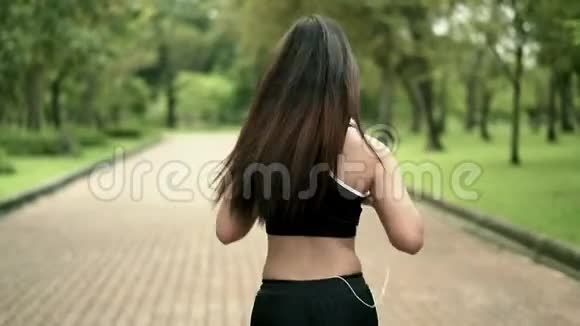 在公园里奔跑的年轻女子后面视频的预览图