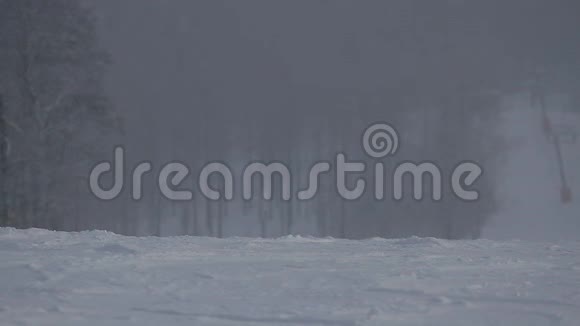 一个滑雪者在一个下雪的冬天滚下一座山视频的预览图