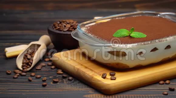 意大利提拉米苏甜点在玻璃烤盘上切割木制背景的盘子视频的预览图