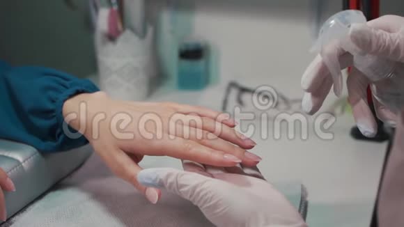 美容师为美容院女性消毒手指甲视频的预览图