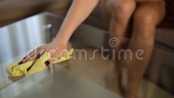 女性手在家用黄布清洁玻璃桌面视频的预览图