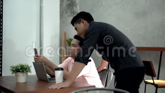 两个年轻人在咖啡店用智能手机视频的预览图