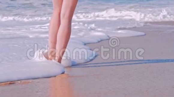 女人走在沙滩上海浪翻滚视频的预览图