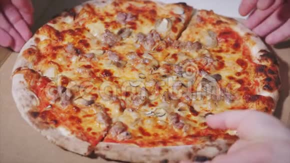 成人和儿童家庭成员的双手从一个打开的盒子里拿出一片热腾腾的意大利披萨视频的预览图