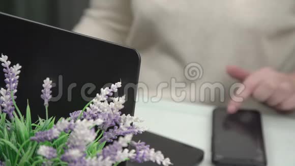 现代笔记本和智能手机上的模糊女士手型视频的预览图