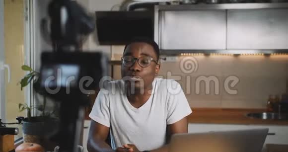 流行的快乐非洲vlogger男子为他的在线博客做直播流使用专业相机在家里慢动作视频的预览图