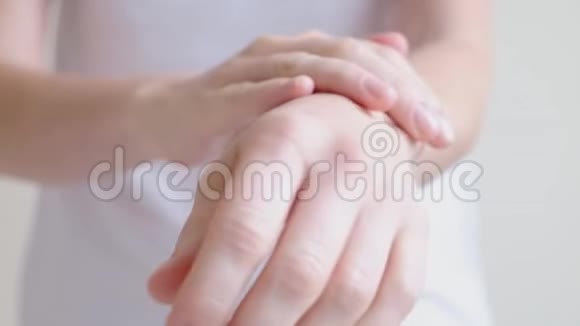 一个年轻女人的手在涂手霜按摩视频的预览图