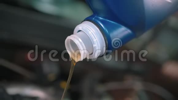 汽车修理店工人用漏斗倒新机油视频的预览图