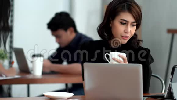 临时青年妇女在工作中使用技术装置视频的预览图