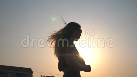 健康的女孩沿着乡村道路慢跑背景是日落年轻的运动女性晚上在户外工作视频的预览图