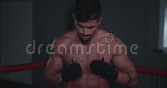 镜头前的肖像漂亮的运动员在拳击场中间进行拳击训练视频的预览图