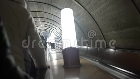 市民乘坐自动扶梯在地铁隧道的特写镜头前经过灯具视频的预览图