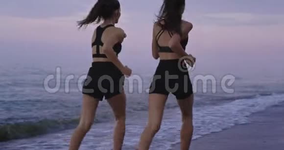 两位年轻女子穿着运动服装在海滩上奔跑一起享受时光听着来自视频的预览图