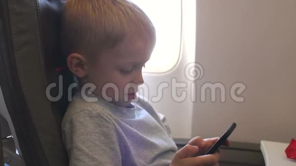 一个小男孩在飞机上玩电子游戏视频的预览图