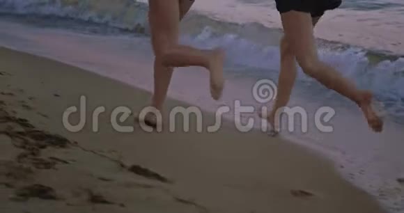 细节特写女士们一起在沙滩上奔跑欣赏迷人的风景视频的预览图