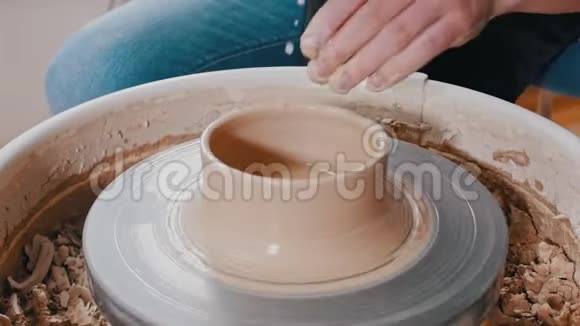 一个陶工用粘土雕刻出一个陶罐其侧面更宽更靠近顶部视频的预览图