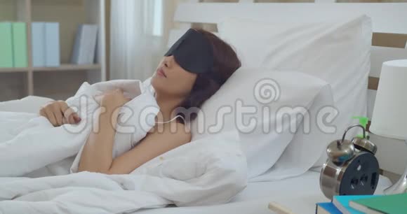 亚洲年轻女子醒来触摸闹钟视频的预览图
