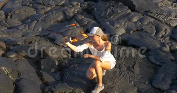 夏威夷Kilauea火山中的一位徒步女孩与流动的熔岩合影视频的预览图