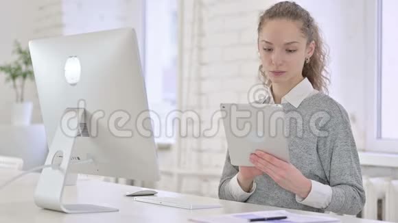 漂亮的年轻拉丁女人使用现代办公室的平板电脑视频的预览图