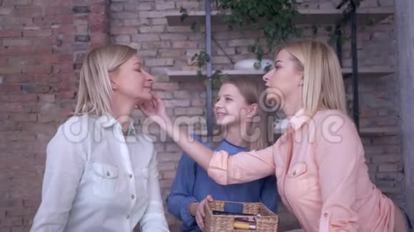 母亲和孩子的关系漂亮的女孩的女儿做专业的弥补时髦的妈妈和化妆品的脸视频的预览图