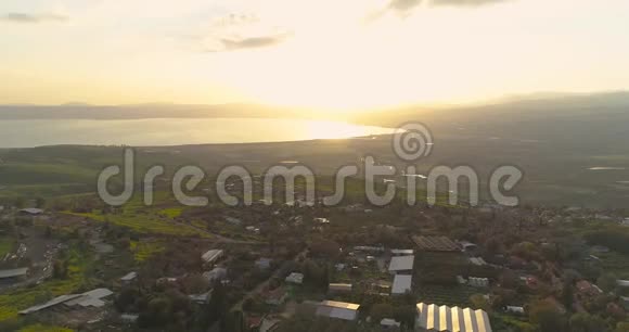 在戈兰高地和以色列北部的泰伯里亚上空的日落处进行空中射击开阔的田野有橙色的绿色景观和视频的预览图