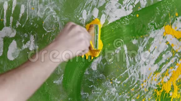 用黄色油漆粉刷白色和绿色墙面视频的预览图