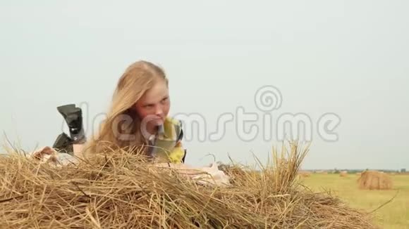 少女躺在干草堆上美丽的阳光日视频的预览图