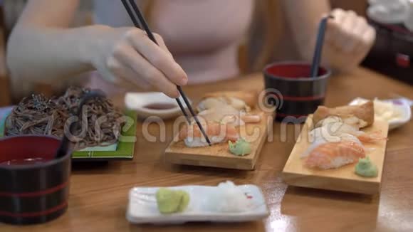 日本餐馆里的一个年轻女人吃寿司旅行到日本的概念视频的预览图