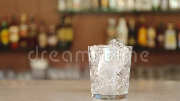 一杯美味的含酒精的尼格尼鸡尾酒酒柜上有橙色的薄片把鸡尾酒倒入杯子里视频的预览图