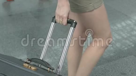 带着手提箱的女孩正在机场散步视频的预览图