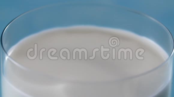 牛奶在缓慢的运动中滴到满杯液体在缓慢的运动中大镜头桌面视频滴视频的预览图