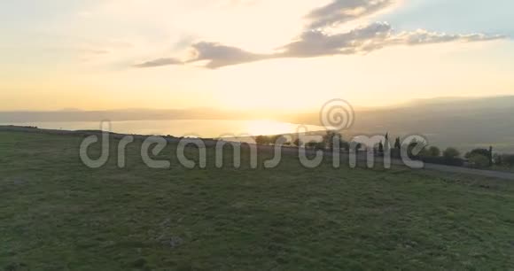 在戈兰高地和以色列北部的泰伯里亚上空的日落处进行空中射击开阔的田野有橙色的绿色景观和视频的预览图