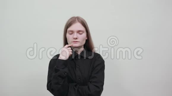 失望的女人在灰色背景的工作室咬指甲看起来不高兴视频的预览图