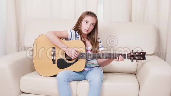 在客厅里学弹六弦声吉他的少女视频的预览图