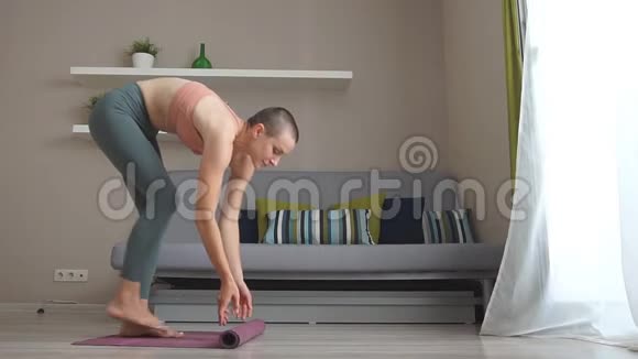 迷人的年轻女性折叠紫罗兰瑜伽或健身垫的肖像视频的预览图