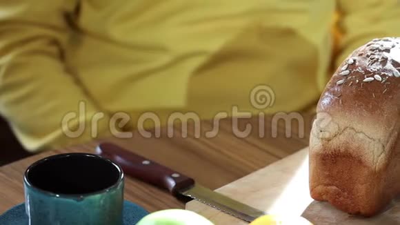 一个男人在早餐时做一个三明治切面包抹黄油放奶酪视频的预览图