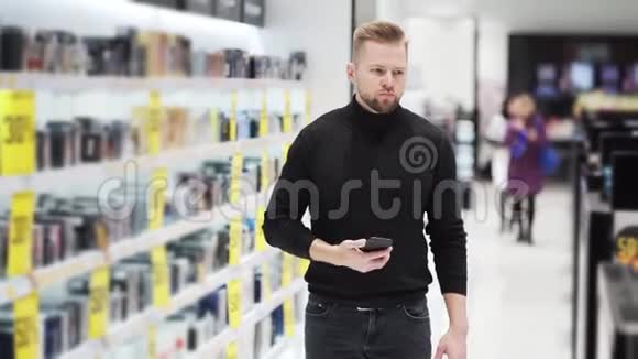 年轻人使用电话在商店里拍照商品和交易货架视频的预览图