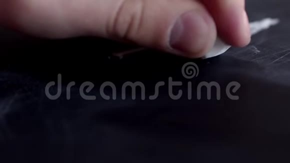 一只手在黑板上用粉笔写下动机这个词镜头在手后移动写下动机这个词视频的预览图