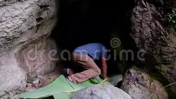 一个人躺在山洞里的香蕉叶床上视频的预览图