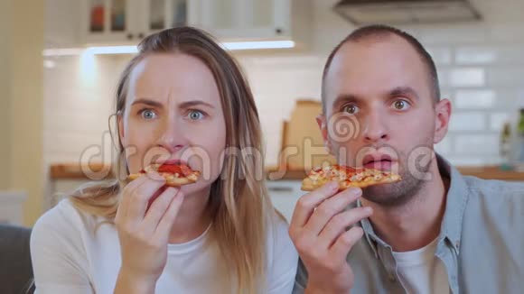 夫妇放松看电视在家吃披萨视频的预览图