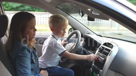 孩子和他的母亲坐车的轮子上他们听音乐视频的预览图