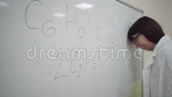 穿实验服的女孩在黑板上写下葡萄糖合成乙醇的公式视频的预览图