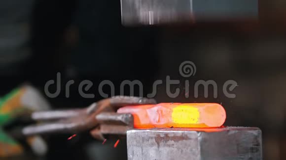 铁匠在工业锻造机的压力下放置一块较长的白炽金属视频的预览图