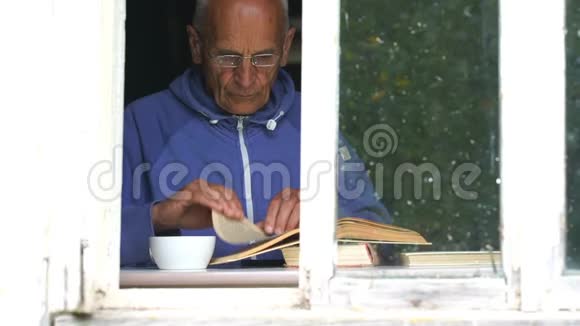 老人在窗台上看书喝茶视频的预览图