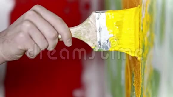 用刷子用黄色油漆粉刷墙壁视频的预览图